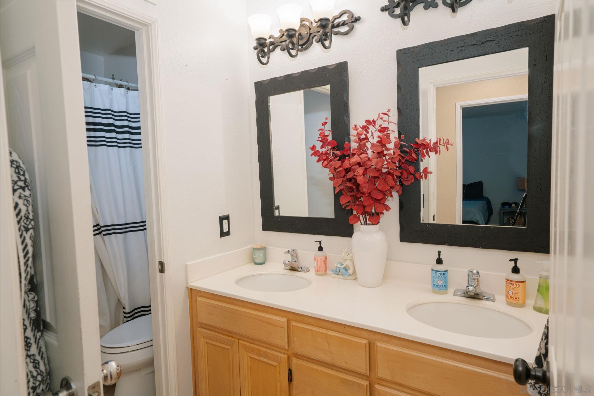 3396 Monique Lane Spring Valley, CA 91977 - Photo 29 of 31 a bathroom with a sink vanity granite toilet and a mirror