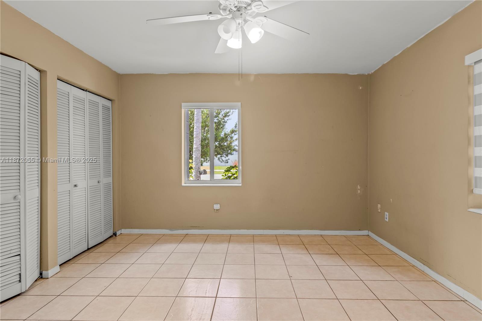 10615 Southwest 200th Street Cutler Bay, FL 33157 - Photo 21 of 35 a view of an empty room with window and chandelier fan