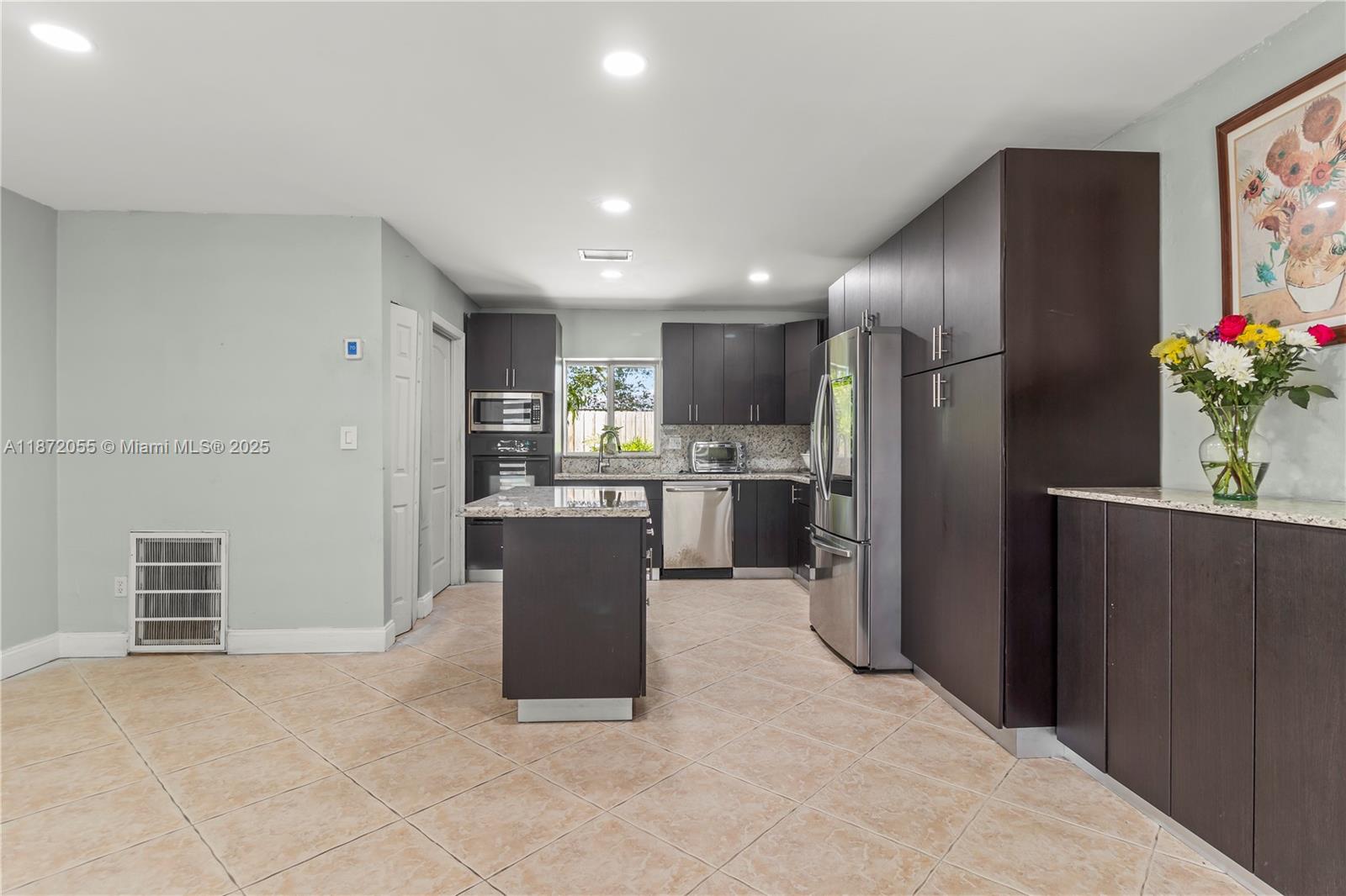 10615 Southwest 200th Street Cutler Bay, FL 33157 - Photo 28 of 35 a kitchen with stainless steel appliances kitchen island granite countertop refrigerator and cabinets