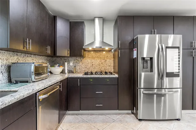 a kitchen with granite countertop stainless steel appliances and wooden cabinets