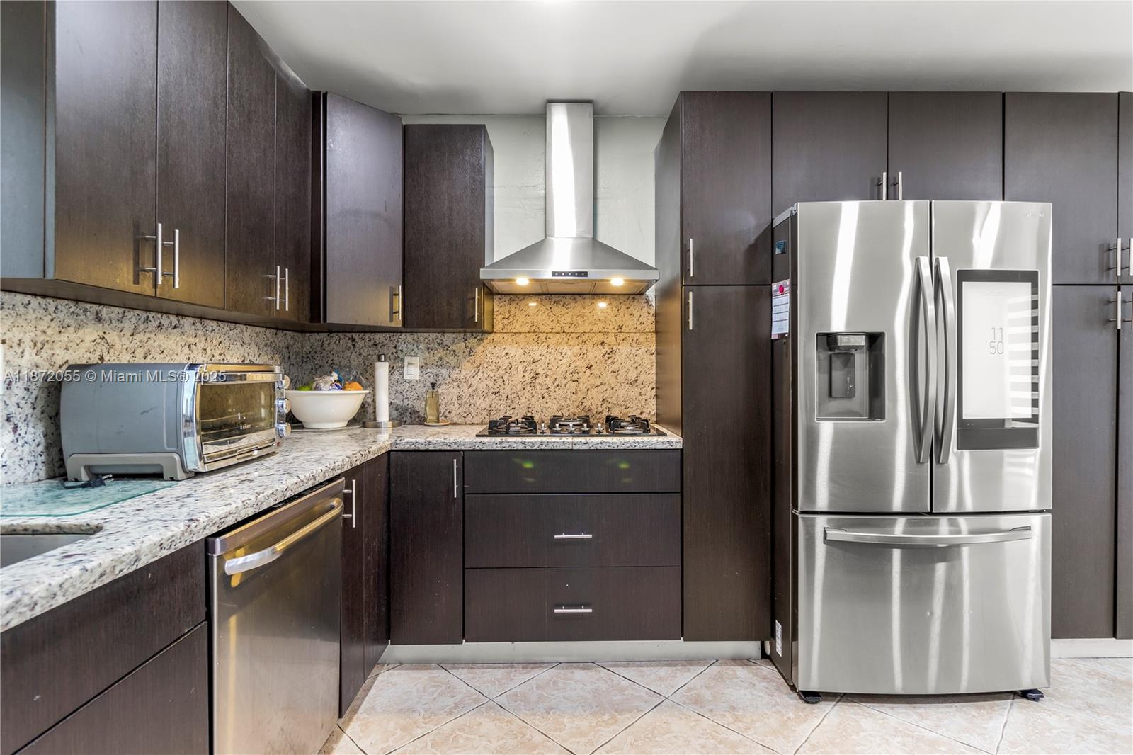 10615 Southwest 200th Street Cutler Bay, FL 33157 - Photo 29 of 35 a kitchen with granite countertop stainless steel appliances and wooden cabinets