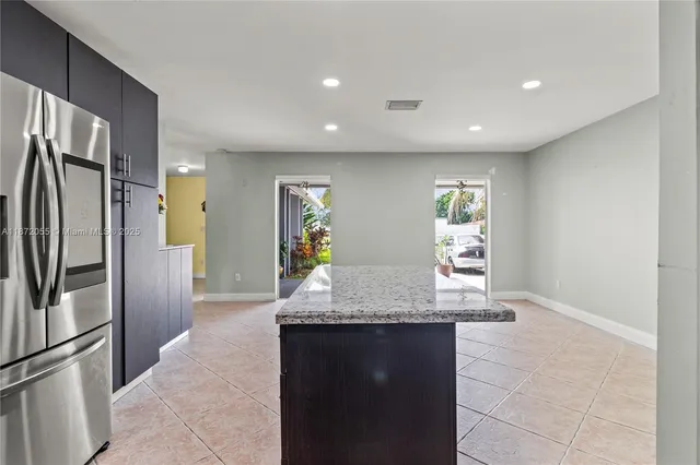 a kitchen with stainless steel appliances granite countertop a refrigerator and a granite counter tops