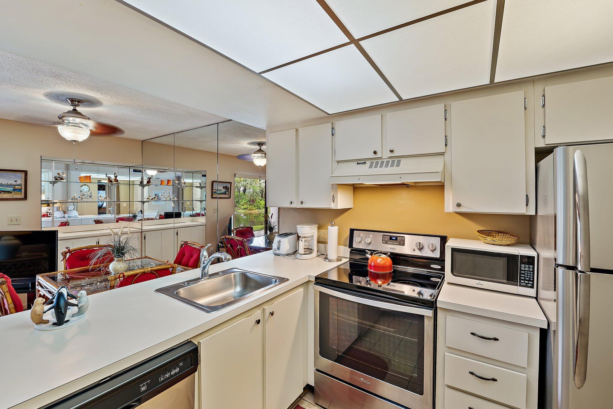 1605 Highway 1, Unit B104 Jupiter, FL 33477 - Photo 12 of 24 a kitchen with a sink appliances and cabinets