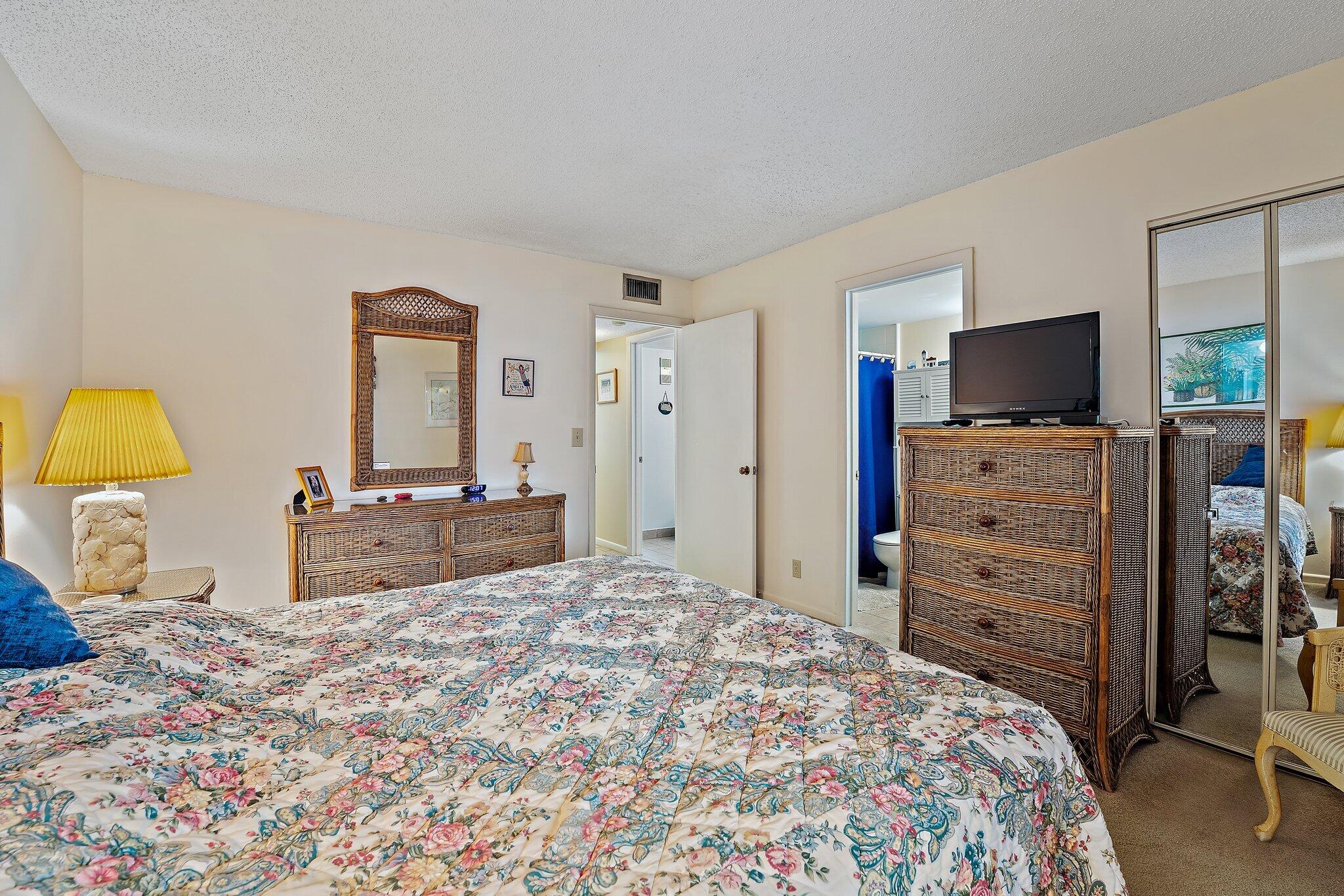 1605 Highway 1, Unit B104 Jupiter, FL 33477 - Photo 18 of 24 a bedroom with a bed and a flat screen tv