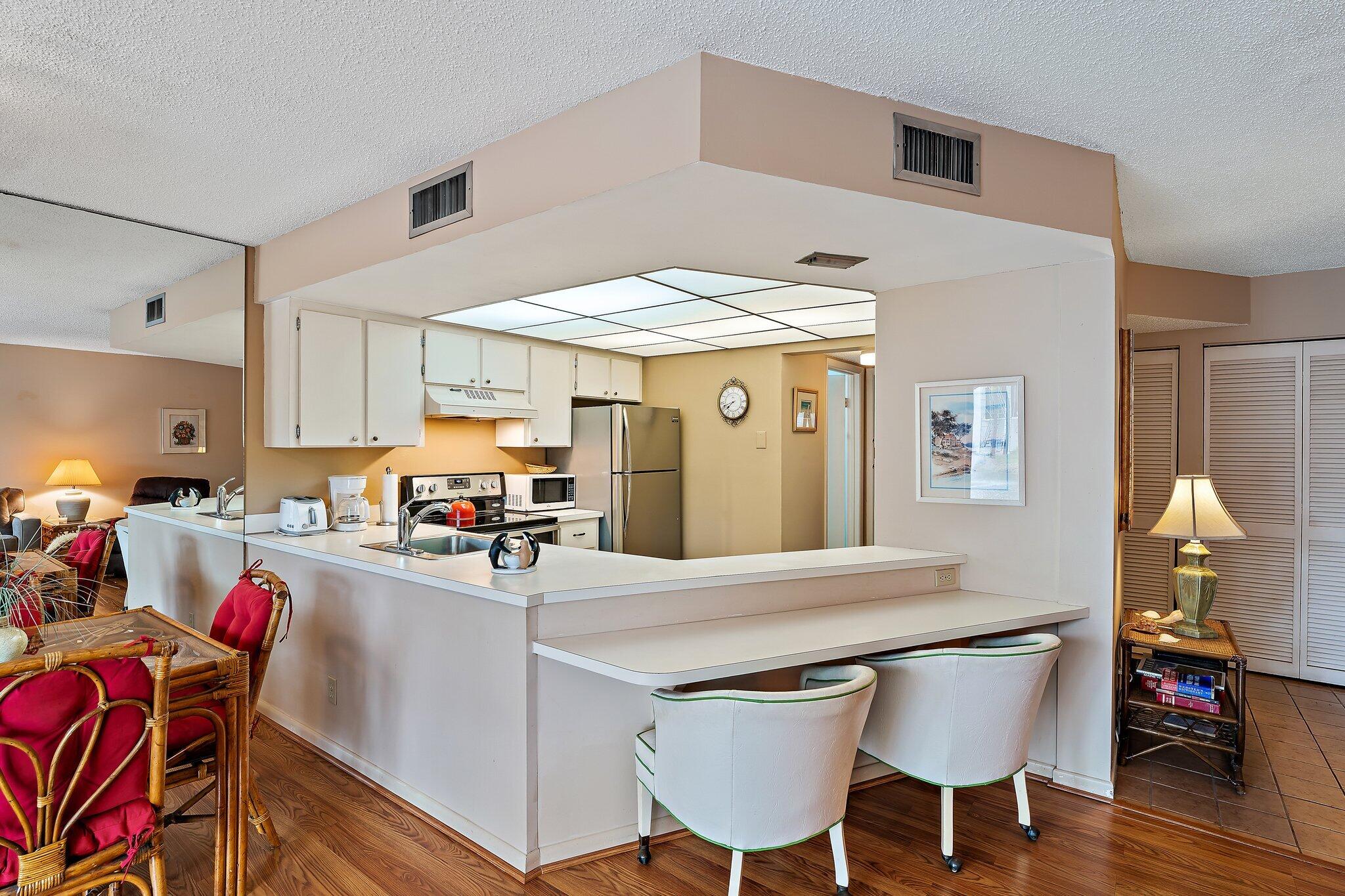 1605 Highway 1, Unit B104 Jupiter, FL 33477 - Photo 10 of 24 a kitchen with a table chairs and a refrigerator