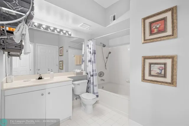 a bathroom with a double vanity sink toilet mirror and shower