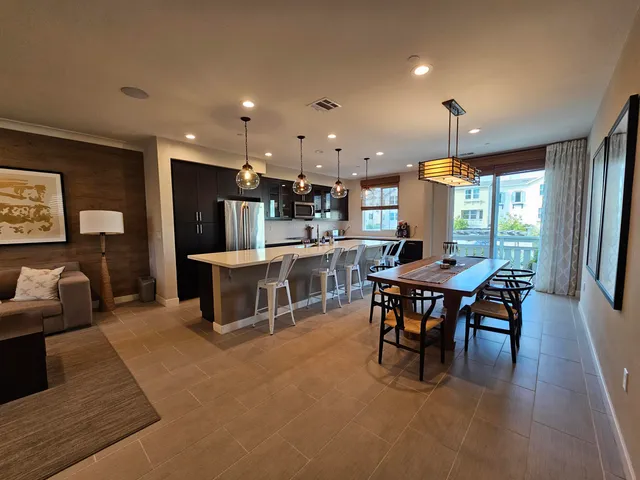 a living room with furniture a wooden floor and kitchen view