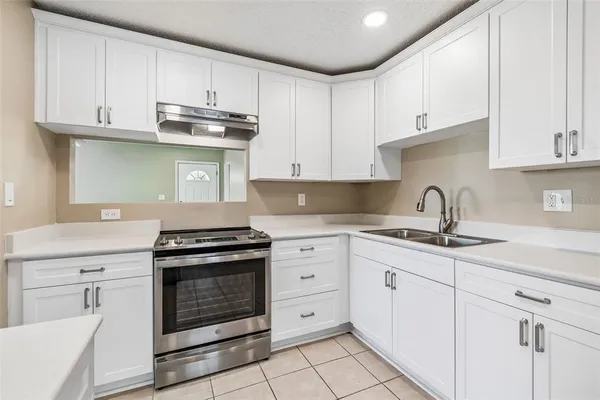 a kitchen with granite countertop white cabinets and stainless steel appliances