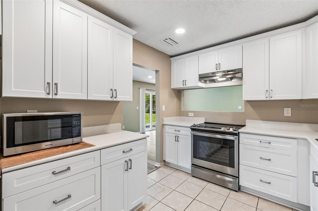 209 Genet Court Sun City Center, FL 33573 - Photo 12 of 31 a kitchen with granite countertop white cabinets and stainless steel appliances