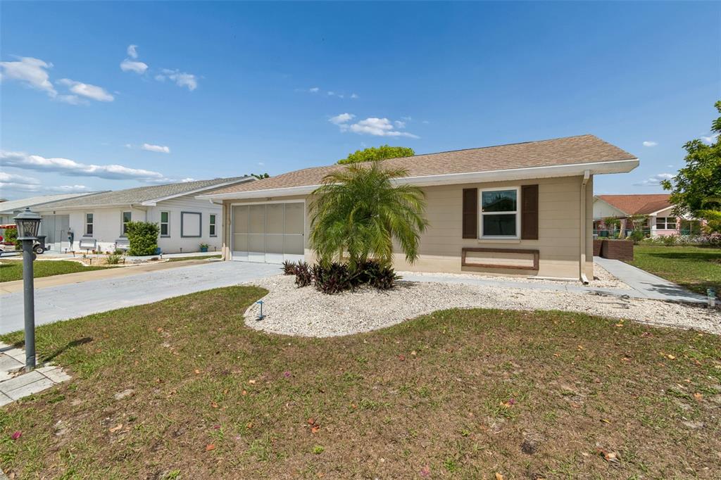 209 Genet Court Sun City Center, FL 33573 - Photo 2 of 31 a white house with palm tree in front of it