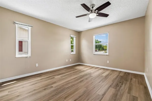 a view of an empty room with window and wooden floor