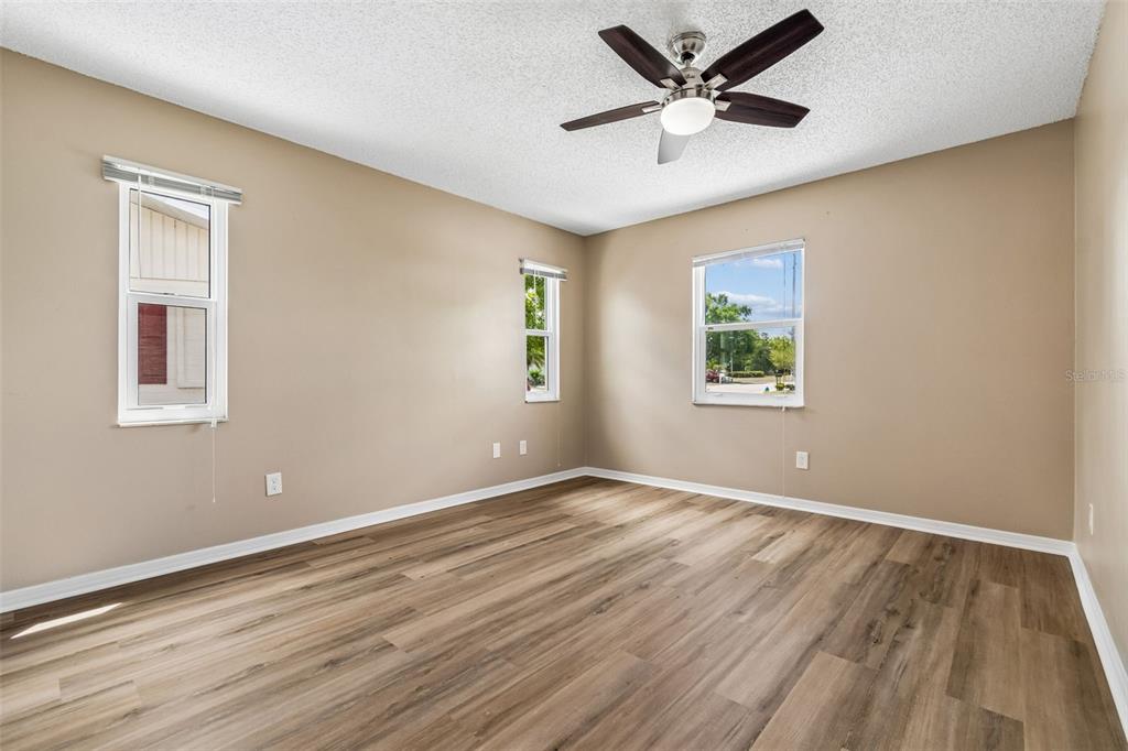 209 Genet Court Sun City Center, FL 33573 - Photo 22 of 31 a view of an empty room with window and wooden floor