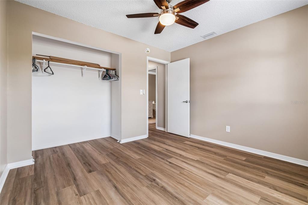 209 Genet Court Sun City Center, FL 33573 - Photo 23 of 31 a view of a room with wooden floor and a ceiling fan