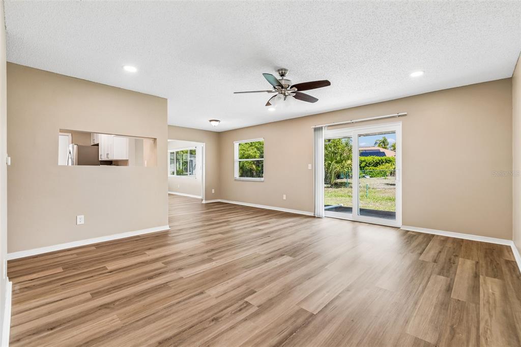 209 Genet Court Sun City Center, FL 33573 - Photo 4 of 31 a view of an empty room with wooden floor and a window