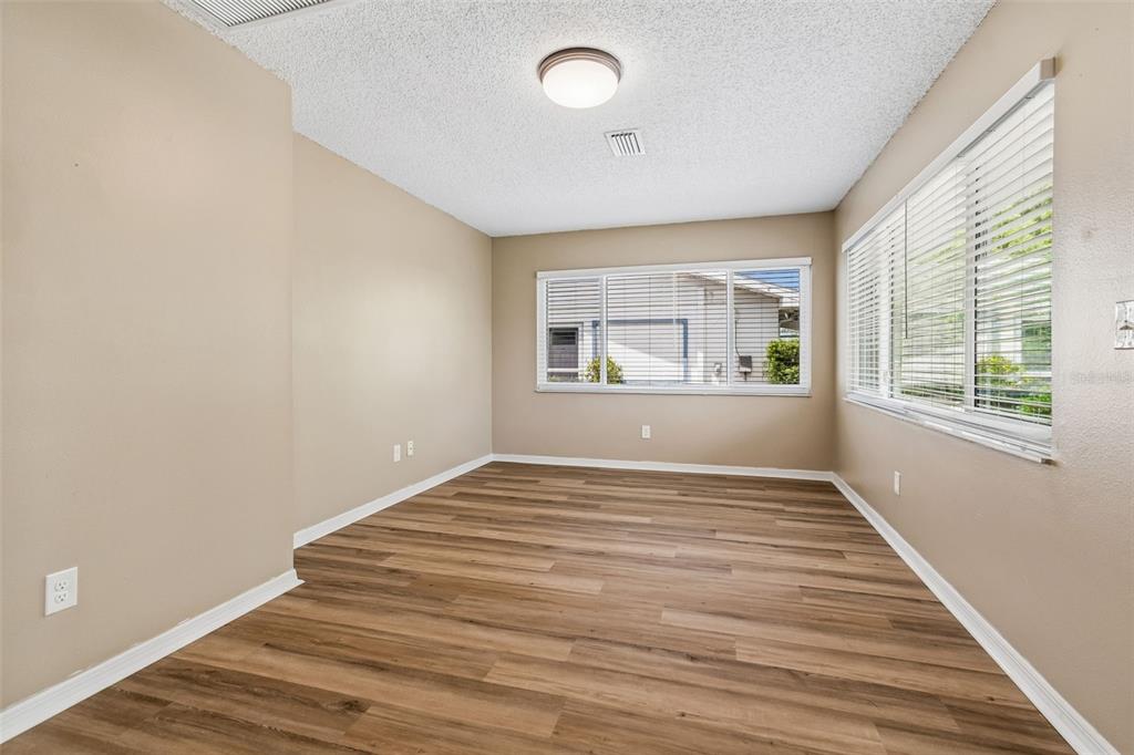 209 Genet Court Sun City Center, FL 33573 - Photo 8 of 31 wooden floor in an empty room with a window