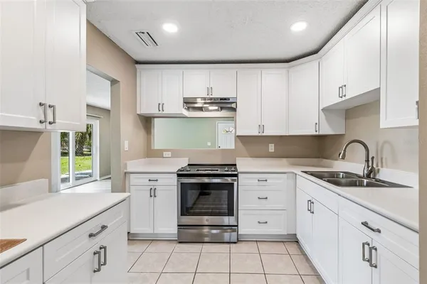 a kitchen with stainless steel appliances granite countertop a stove sink and cabinets