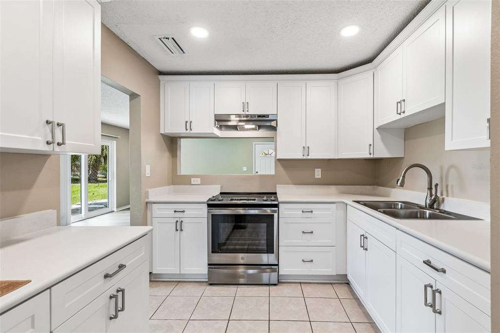 209 Genet Court Sun City Center, FL 33573 - Photo 10 of 31 a kitchen with stainless steel appliances granite countertop a stove sink and cabinets