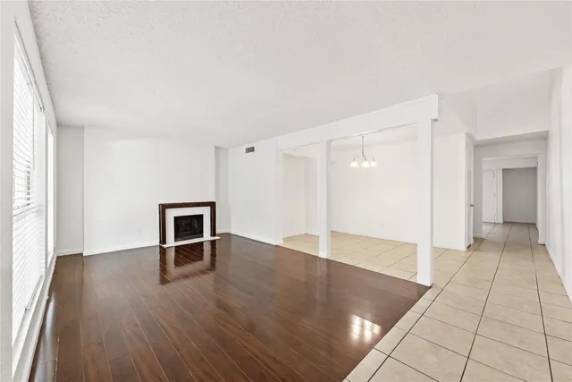 an empty room with wooden floor and fireplace