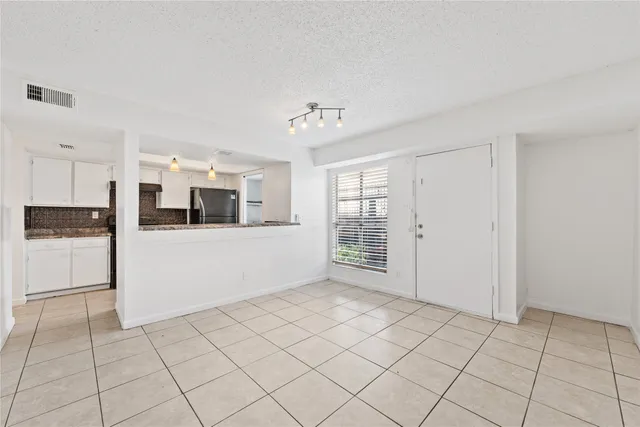 a view of a kitchen with an empty space and a window