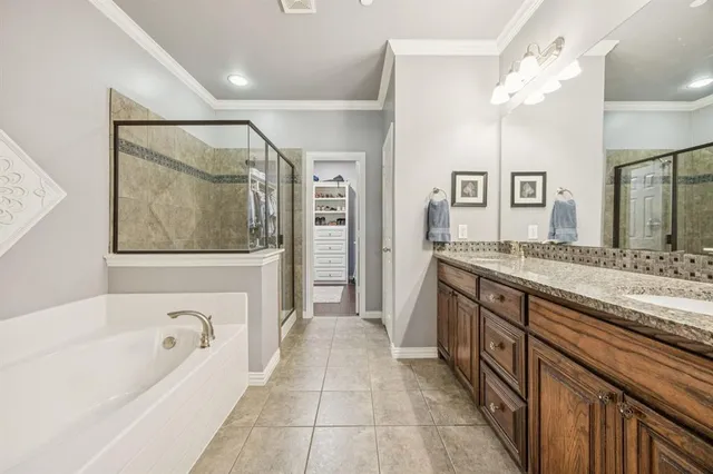 a spacious bathroom with a granite countertop tub a double vanity sink a vanity and a large mirror