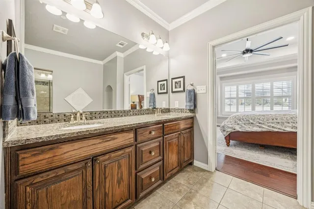 a spacious bathroom with a granite countertop double vanity and a mirror
