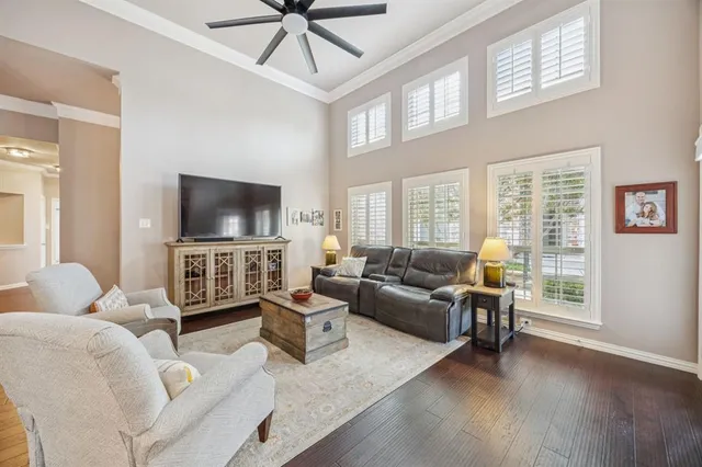 a living room with furniture a flat screen tv and a large window