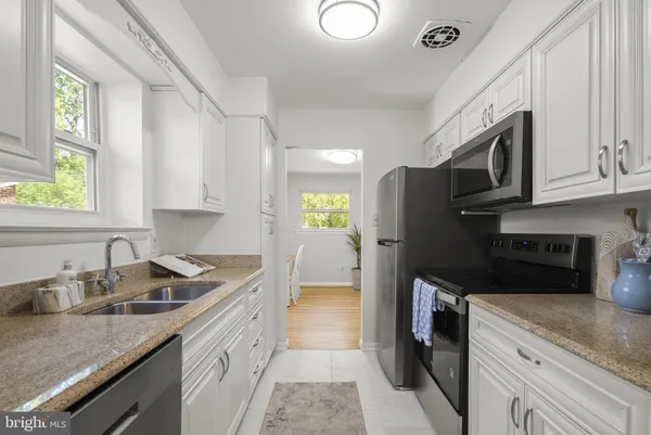 a kitchen with stainless steel appliances granite countertop a sink stove and cabinets