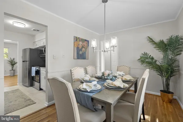 a view of a dining room with furniture a chandelier and wooden floor