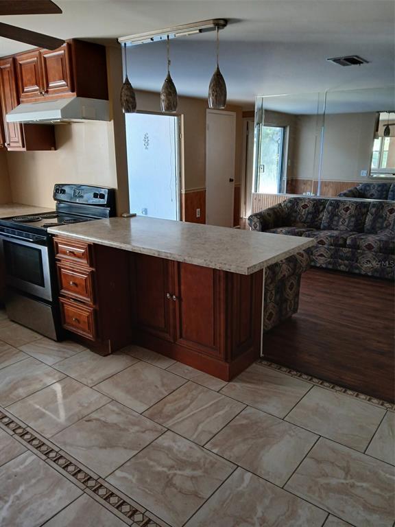 8809 Avondale Lane Hudson, FL 34667 - Photo 14 of 20 a kitchen with stainless steel appliances granite countertop a stove a sink and a microwave