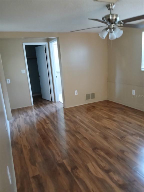 8809 Avondale Lane Hudson, FL 34667 - Photo 10 of 20 an empty room with wooden floor fan and windows