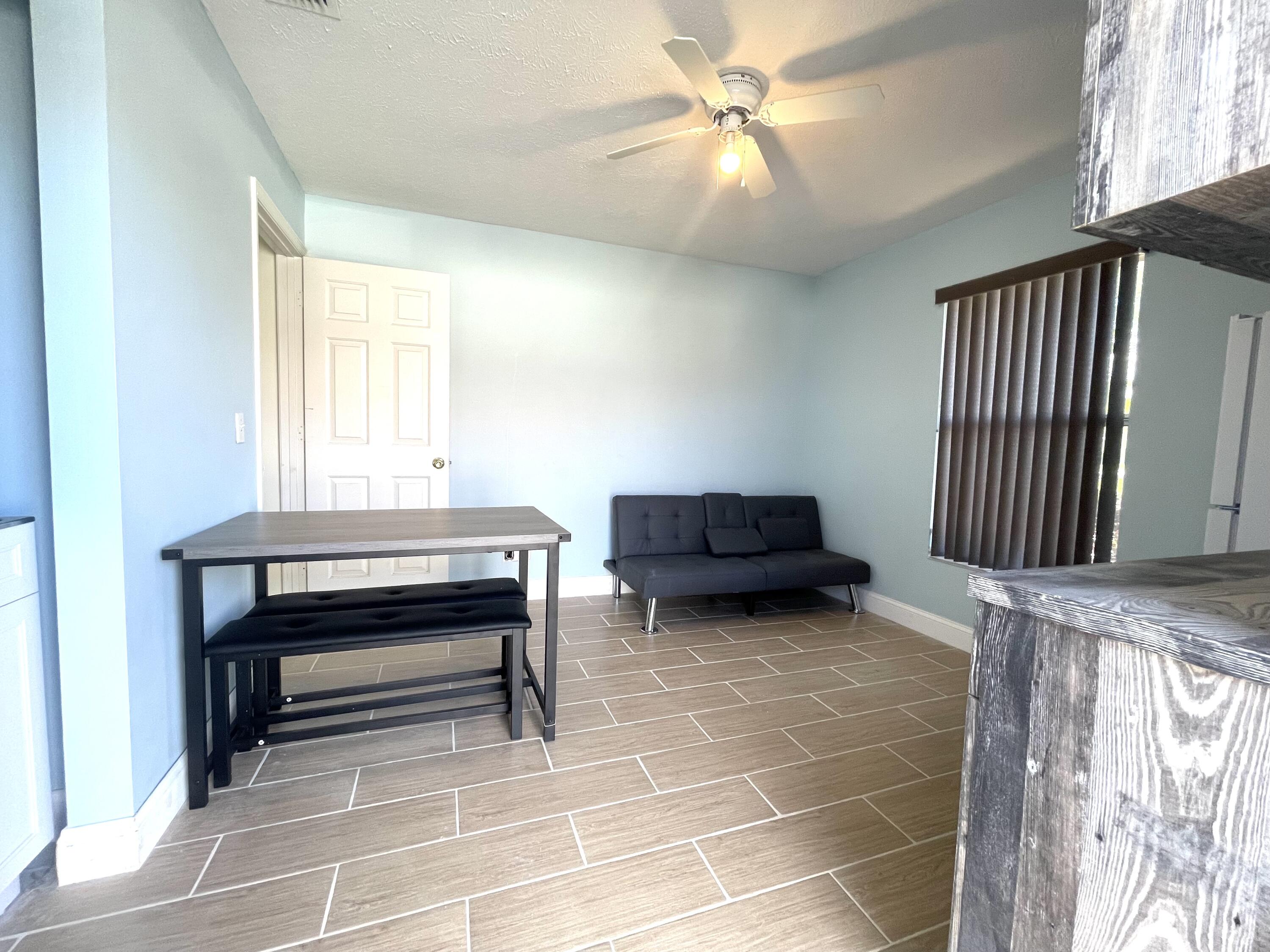 a living room with furniture a ceiling fan and a window
