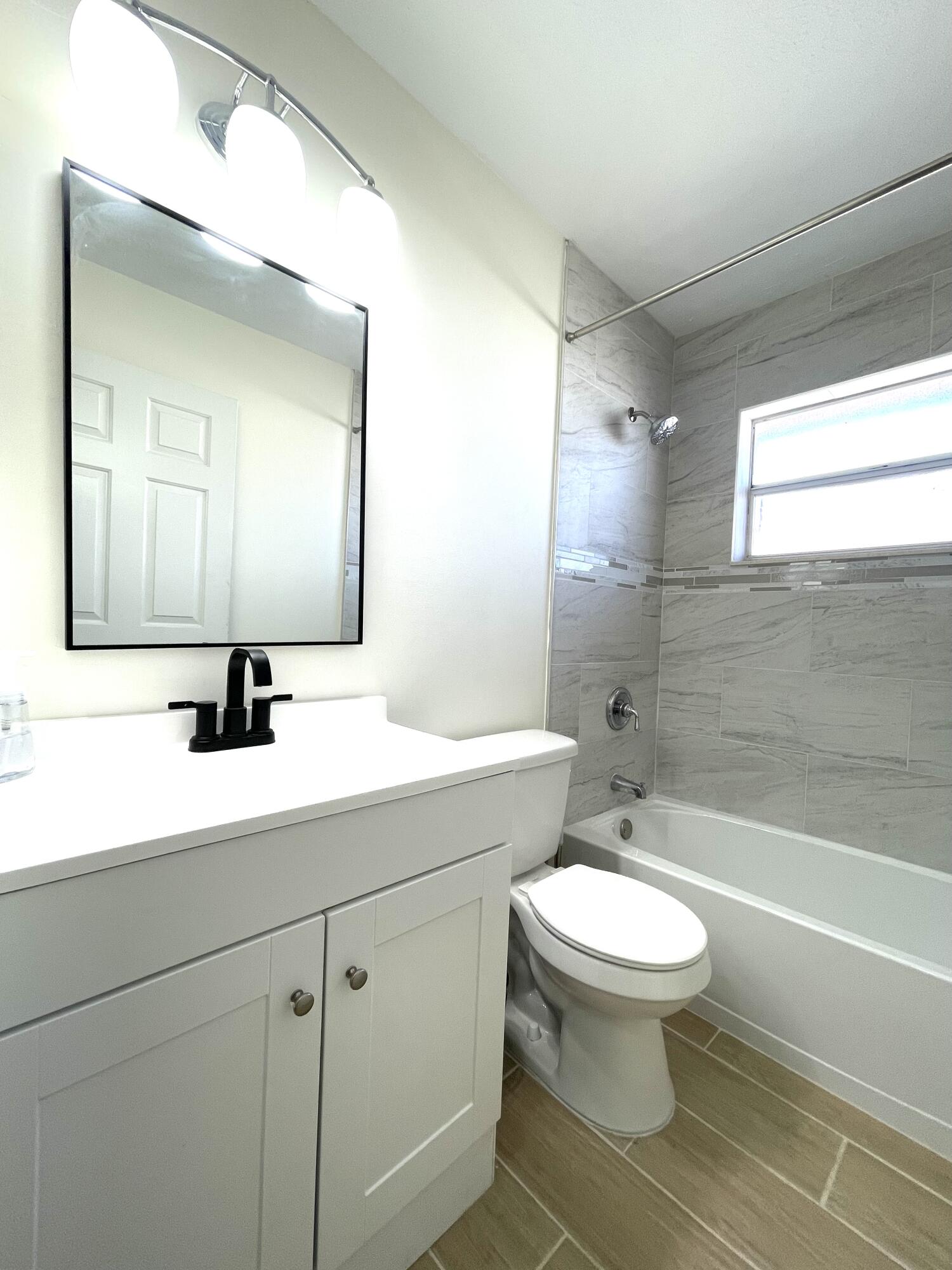 5753 Southeast Mercedes Avenue Stuart, FL 34997 - Photo 12 of 24 a bathroom with a sink a toilet a mirror and shower