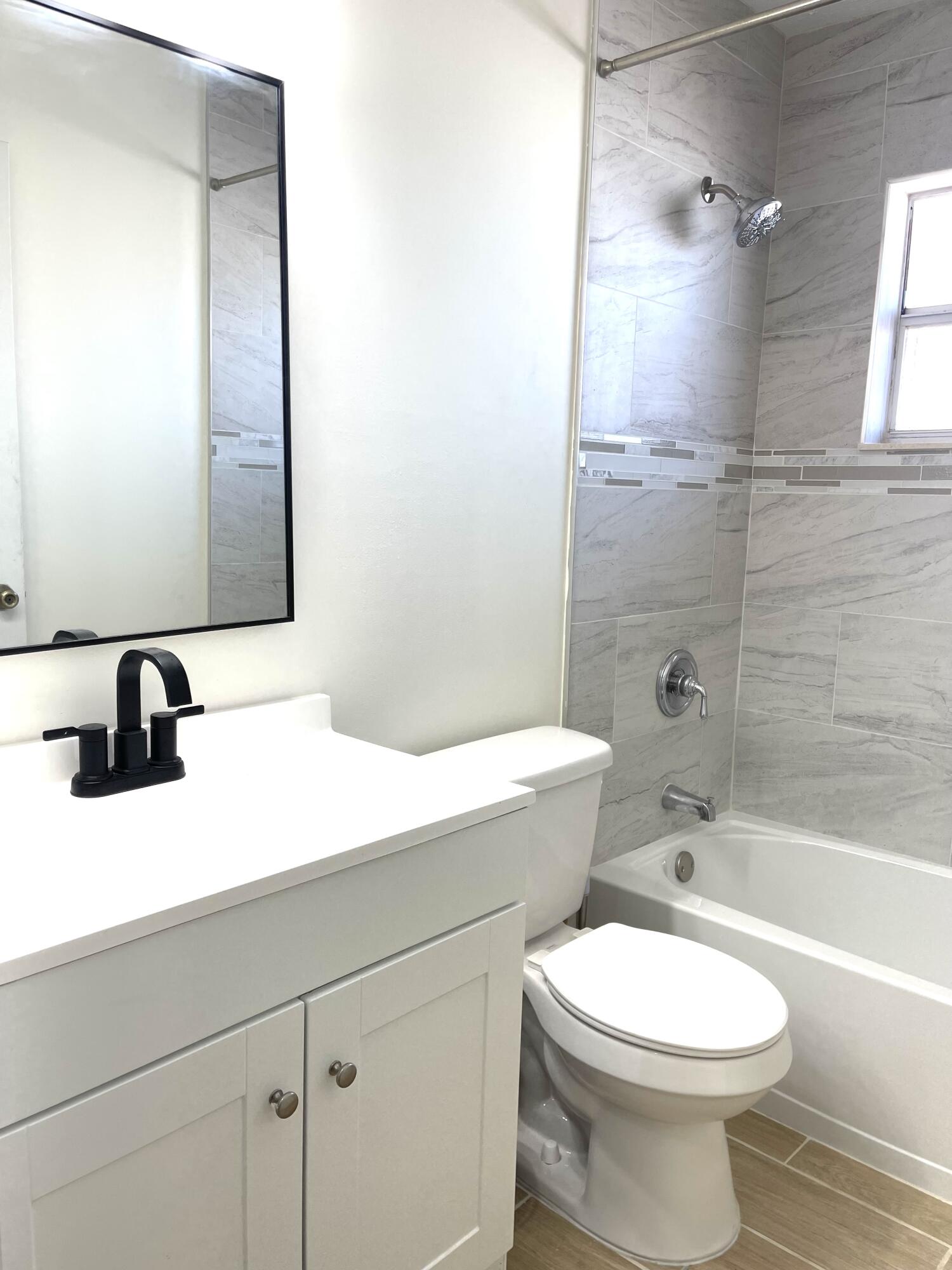 5753 Southeast Mercedes Avenue Stuart, FL 34997 - Photo 13 of 24 a bathroom with a sink a toilet and shower