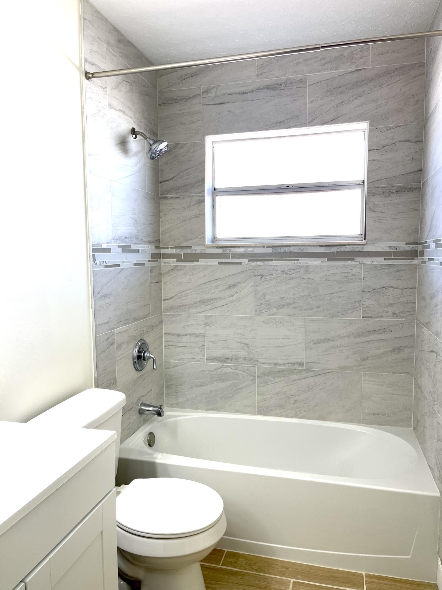 5753 Southeast Mercedes Avenue Stuart, FL 34997 - Photo 14 of 24 a bathroom with a granite countertop toilet a sink and bathtub