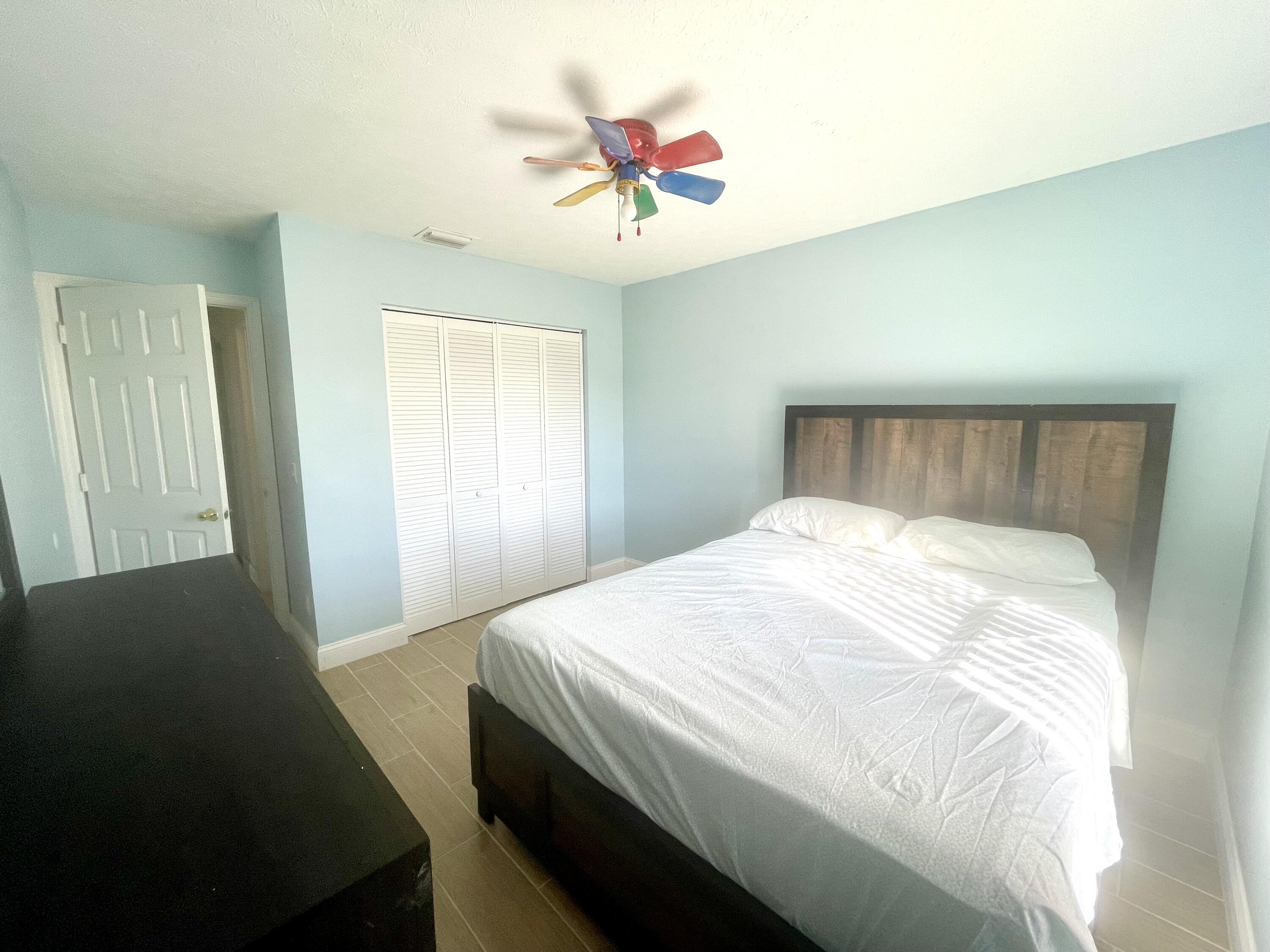 5753 Southeast Mercedes Avenue Stuart, FL 34997 - Photo 16 of 24 a bed sitting in a bedroom next to a window