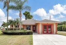 5753 Southeast Mercedes Avenue Stuart, FL 34997 - Photo 24 of 24 a front view of a house with a garden and lake view