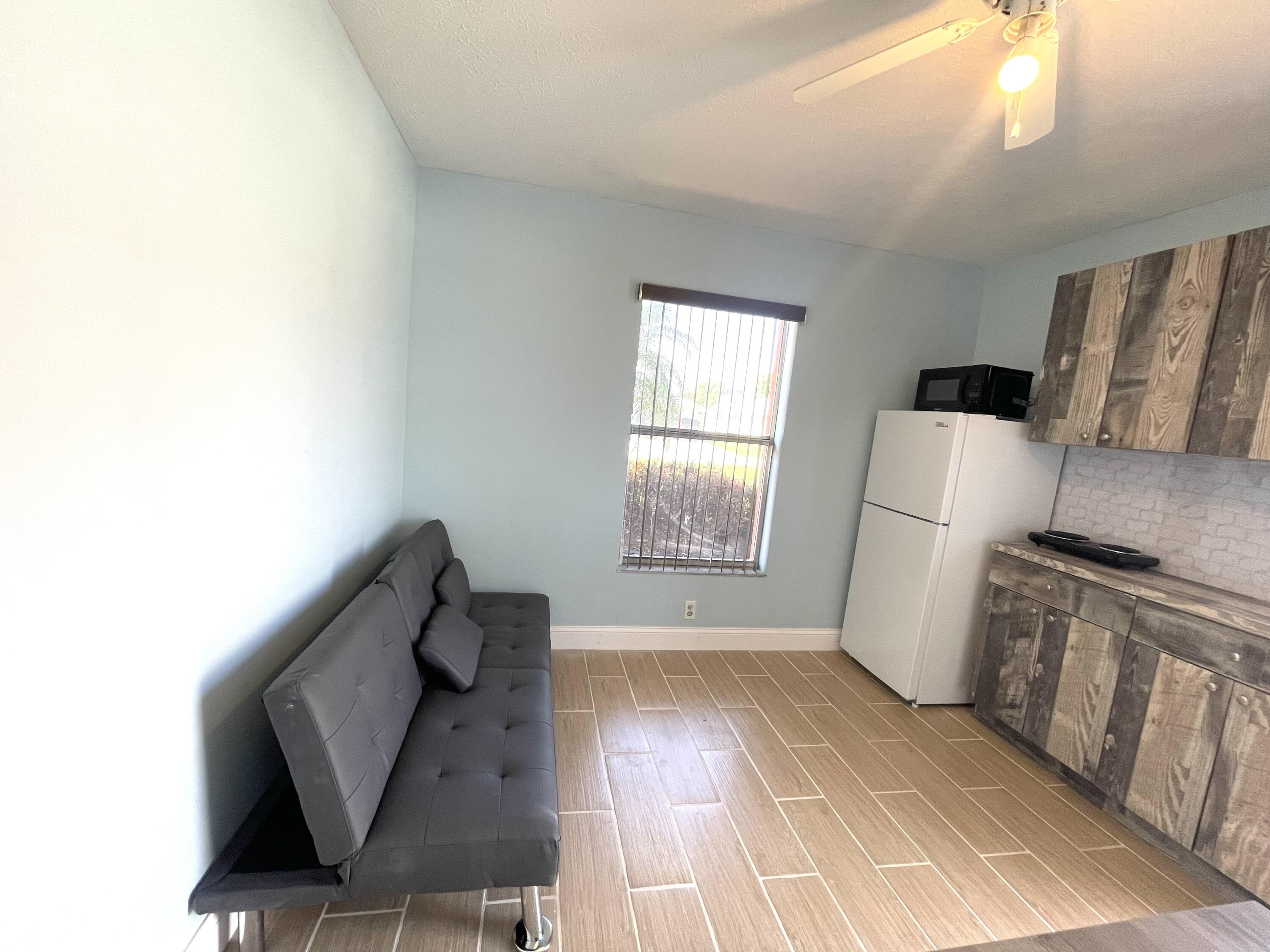 5753 Southeast Mercedes Avenue Stuart, FL 34997 - Photo 9 of 24 a view of a kitchen with fridge and wooden floor