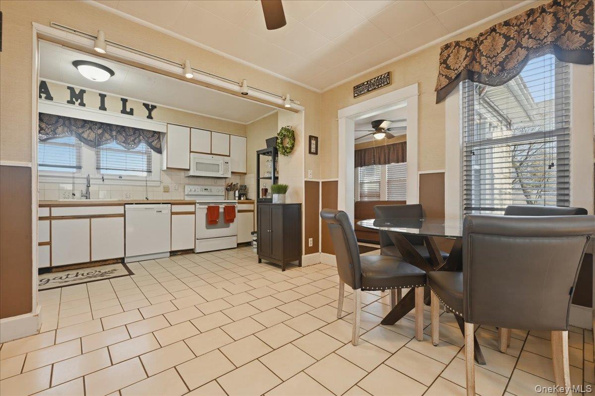1165 Meadowbrook Road Merrick, NY 11566 - Photo 13 of 36 a kitchen with cabinets and chairs