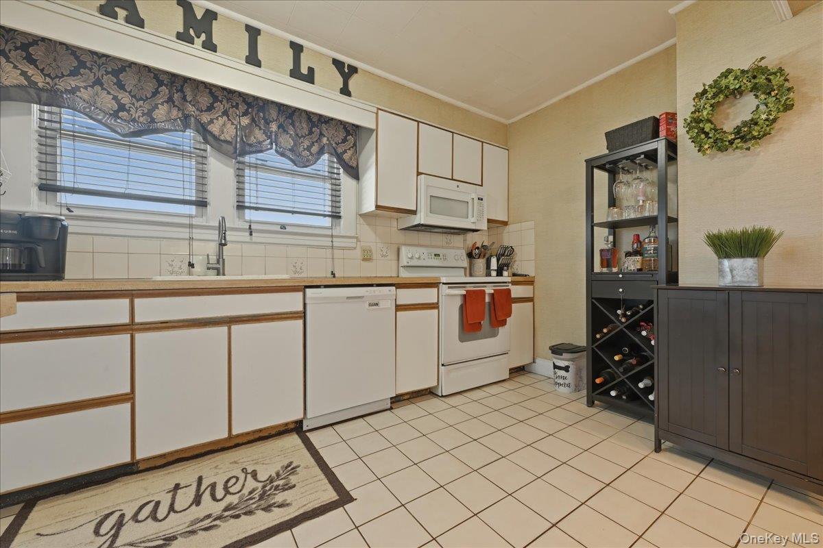 1165 Meadowbrook Road Merrick, NY 11566 - Photo 15 of 36 a kitchen with a sink and cabinets