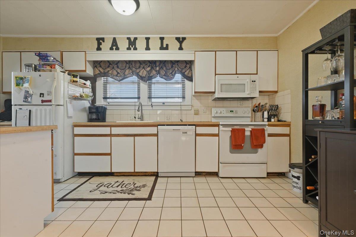 1165 Meadowbrook Road Merrick, NY 11566 - Photo 16 of 36 a kitchen with stainless steel appliances a stove and cabinets