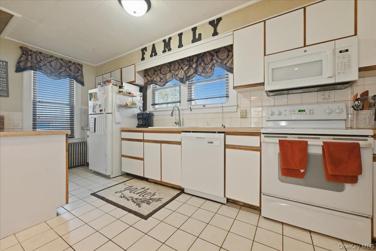 1165 Meadowbrook Road Merrick, NY 11566 - Photo 17 of 36 a kitchen with stainless steel appliances granite countertop a sink a stove a refrigerator and cabinets