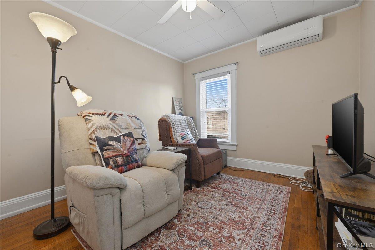 1165 Meadowbrook Road Merrick, NY 11566 - Photo 24 of 36 a living room with furniture and a flat screen tv