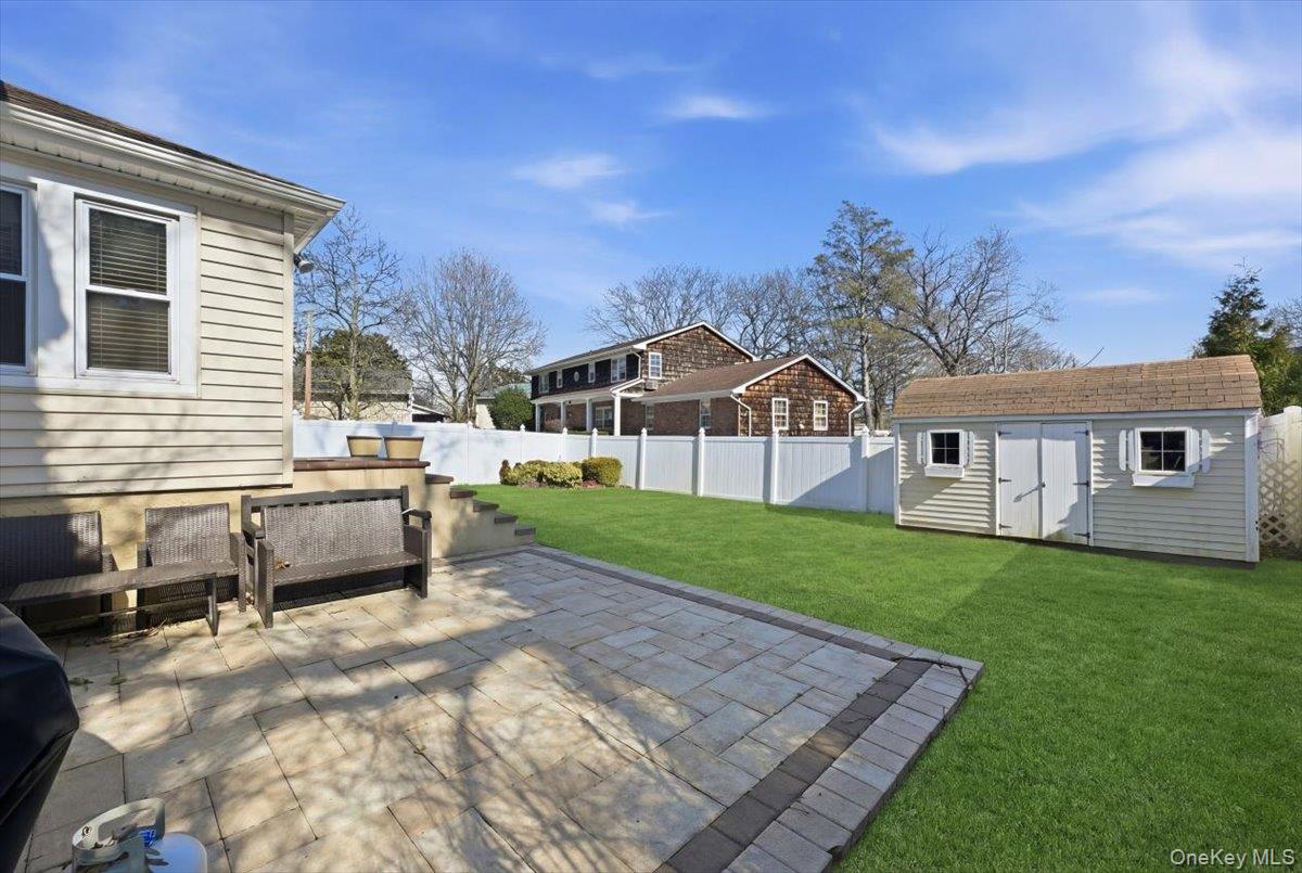 1165 Meadowbrook Road Merrick, NY 11566 - Photo 31 of 36 a view of a white house in front of a big yard with large trees