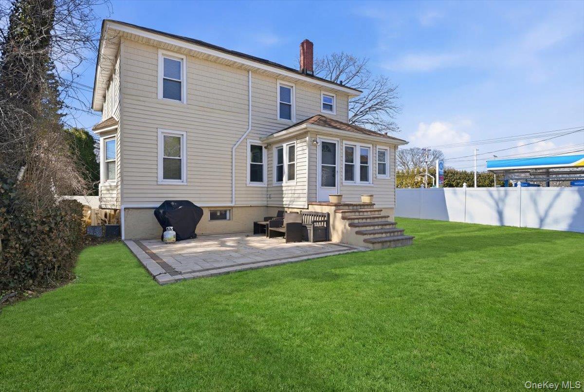 1165 Meadowbrook Road Merrick, NY 11566 - Photo 33 of 36 a front view of a house with a yard patio and fire pit