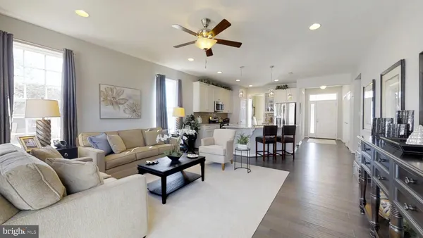 a living room with furniture kitchen view and a large window