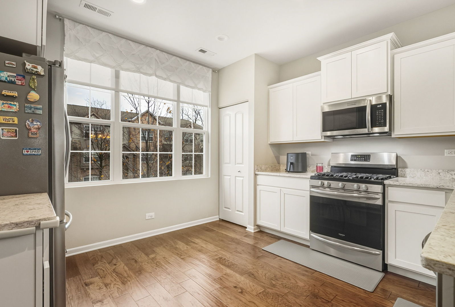 8536 Grove Street Morton Grove, IL 60053 - Photo 12 of 26 a kitchen with granite countertop a stove and a microwave
