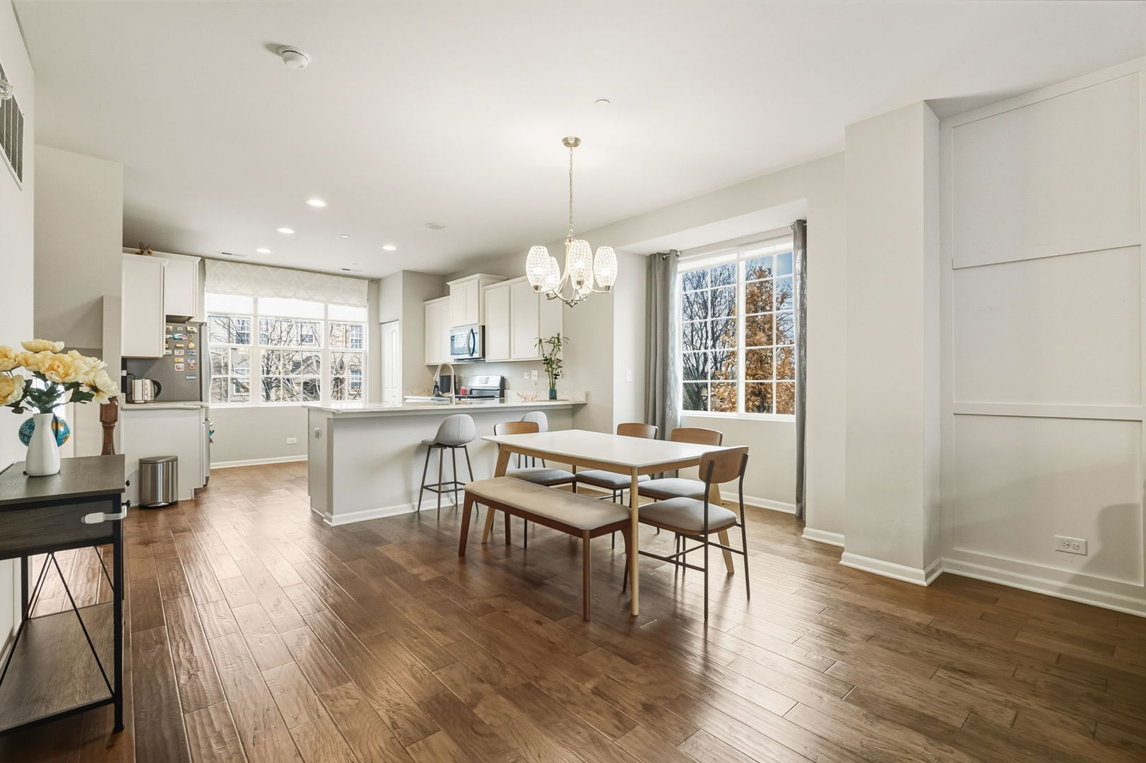 8536 Grove Street Morton Grove, IL 60053 - Photo 7 of 26 a dining room with wooden floor a chandelier a wooden table and chairs