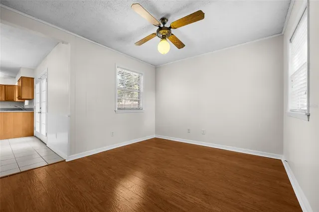 an empty room with a window and a ceiling fan
