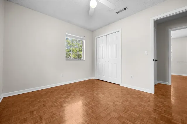 an empty room with a window and wooden floor