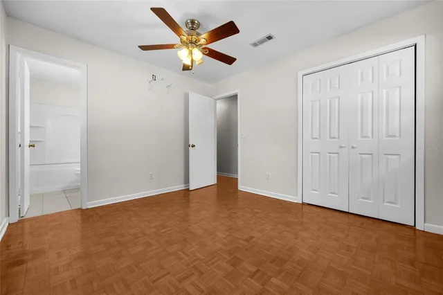 an empty room with a ceiling fan and a window
